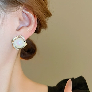 Close-up of vintage resin pearl drop earring with rhinestones on golden frame