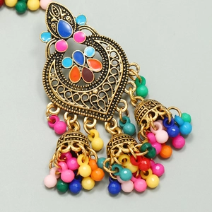 Macro view of Bohemian Jhumka earrings with gold alloy filigree and colorful enamel beads