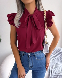 Detail of elegant wine red chiffon shirt featuring a bow tie collar and ruffle sleeves