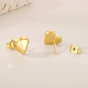 Detailed view of 18k gold plated heart stud earrings with geometric facets and secure backings