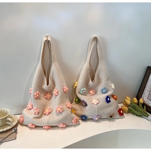 Detail of knitted tote bag showing 3D handmade floral embroidery and soft cotton texture