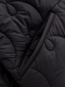 Macro shot of black wavy quilted jacket fabric with premium glossy finish and pocket detail
