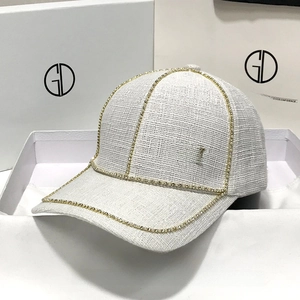 Elegant off-white tweed baseball cap featuring rhinestone edges and a gold metal M logo