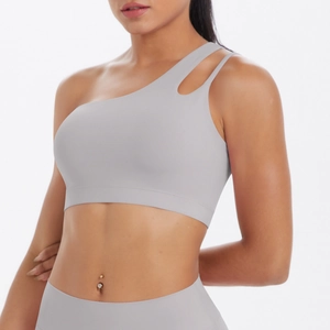 Detail of light grey asymmetric one-shoulder sports bra with modern cutout design