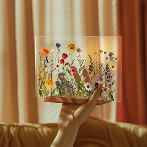 Close-up of a floral acrylic table ornament with dried flowers and a wooden base