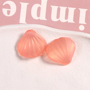 Vista macro de dos dijes de concha de resina rosa nacarada para joyas y accesorios DIY