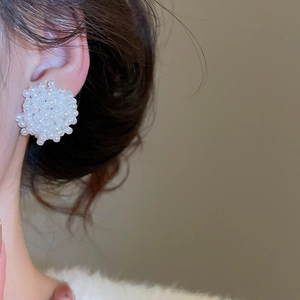 Détail macro de boucles d'oreilles élégantes en grappe de perles au style vintage