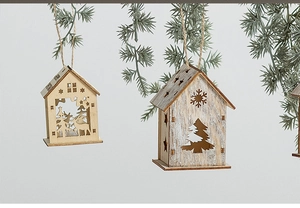 Dettaglio di casette natalizie in legno intagliate al laser con motivi a fiocco di neve