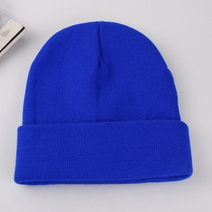 Close-up of solid blue knitted beanie showing detailed warm ribbed texture and fabric