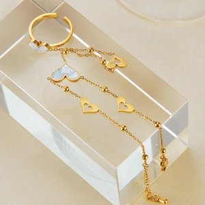 Detailed shot of gold heart ring and bracelet set with white mother of pearl inlay