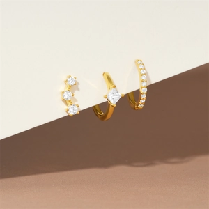 Detailed view of 3-piece gold S925 silver earring set with cubic zirconia on white card