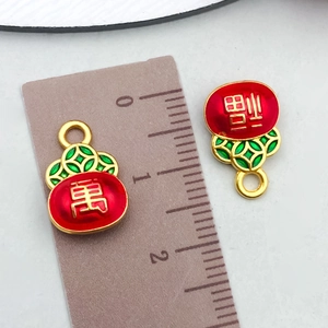 Macro shot of 1.5cm red and green enamel lucky pouch pendants with gold coin patterns