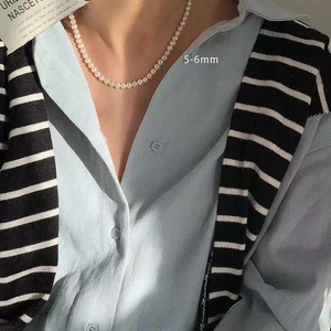 French vintage pearl necklace with 5-6mm beads worn by model on blue shirt