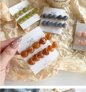 Detail of jelly-colored heart and round beaded hair clips on a display card