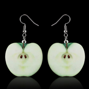 Macro shot of realistic green apple slice earrings with silver hooks on black background