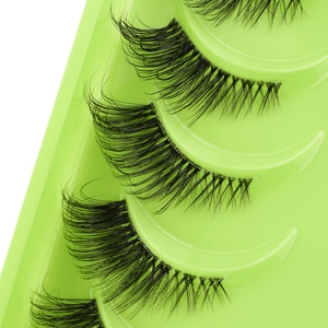 Detailed view of dense black synthetic half eyelashes arranged in a green tray