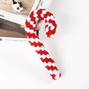 Detail of red and white woven cotton candy cane dog toy on a decorative background