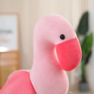 Close-up of soft pink flamingo plush toy with detailed textures and embroidery