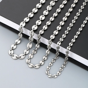 Detail of silver stainless steel coffee bean links resting on a black notebook