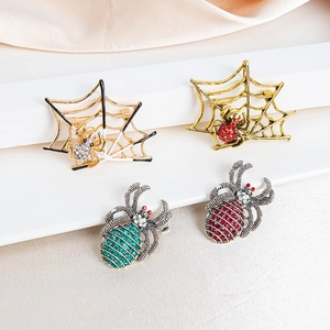 Spider web and insect brooches with colorful rhinestones on a white display stand