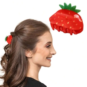 Red strawberry claw clip displayed on hair and as a close-up product view for styling