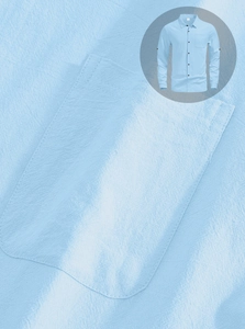 Close-up detail of light blue men's linen shirt fabric texture and front pocket