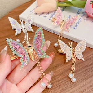 Close-up of butterfly hair clip with pearl tassels and shimmering wings for girls