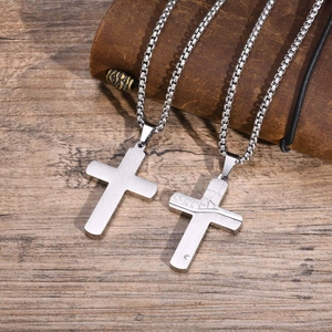 Detail view of silver stainless steel cross pendants with smooth and cracked textures