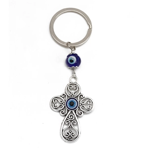 Dettaglio del portachiavi a croce in argento antico con perline occhio blu e intagli
