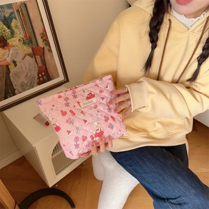 Quilted pink makeup bag with rabbit patterns held by a woman in a cozy home setting