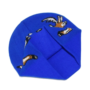 Detailopname van blauwe gebreide muts met wit en oranje rendierpatroon textuur