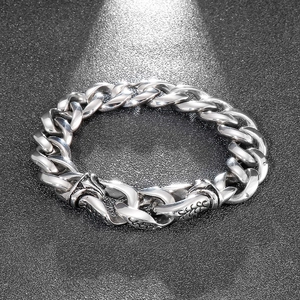 Macro shot of silver Cuban link bracelet with vintage relief patterns on polished steel