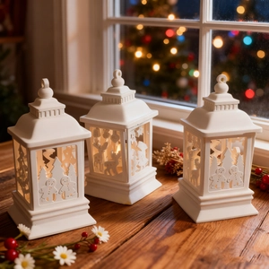 Three white Christmas lantern resin molds with warm light and festive cutout patterns
