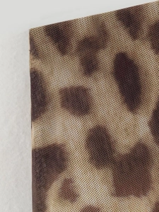 Macro shot of leopard print mesh fabric showing delicate semi-transparent textile texture