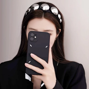 Close-up of a wide black headband with silver metallic studs worn by a model