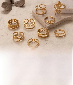 Detailed view of gold plated snake-shaped and textured titanium steel rings on stone base