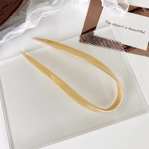 U-shaped hair pin in marble pattern acetate shown on a textured decorative background