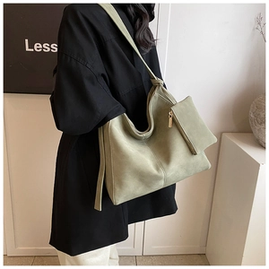 Detail of avocado green suede tote bag showing knot strap and detachable small coin purse