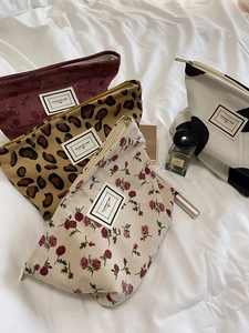 Detail showing various patterned corduroy makeup bags with zippers on white fabric