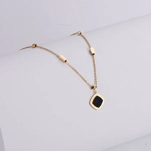 Detail of a gold square pendant with black inlay, Roman numerals and cube chain
