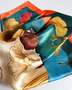 Detail of silk-satin square scarf featuring ginkgo leaf print and glossy finish
