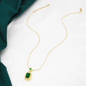 Vintage emerald pendant necklace in gold with white diamonds on elegant silk fabric