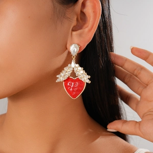 Close-up of red heart resin drop earrings with crystal wings on model's ear