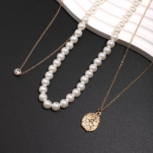 Driedelige gouden herenketting set met witte parels en een reliëf munt hanger