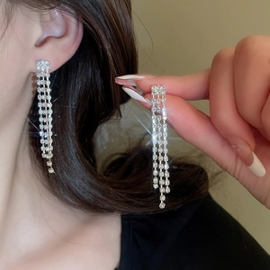 Close-up of sparkling silver tassel earrings with multiple rows of rhinestones for women
