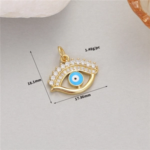 Macro shot of 14K gold evil eye pendant with white zircon and blue enamel detail