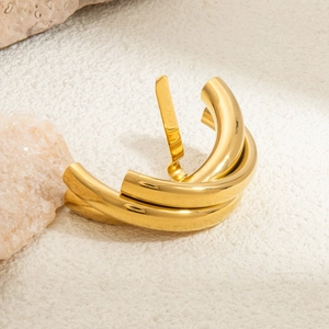 Detailed view of chunky gold plated stainless steel C-hoop earring on a stone surface