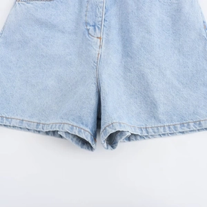 Detail of high-quality stitching on the crotch and hem of light blue denim romper shorts