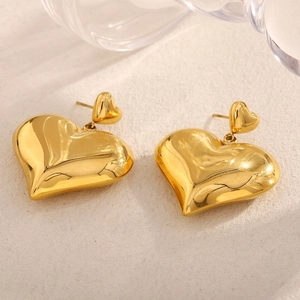 Macro shot of 18K gold-plated double hollow heart earrings on a minimalist background