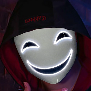 Close-up of LED glowing mask with white neon smiling face design and dark hoodie